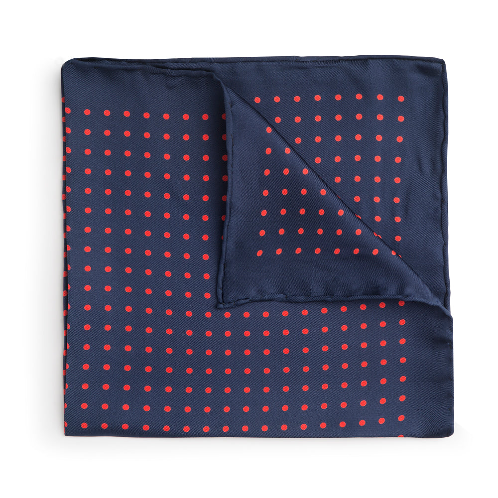 Navy silk pocket square with red polka dots and hand-rolled edges