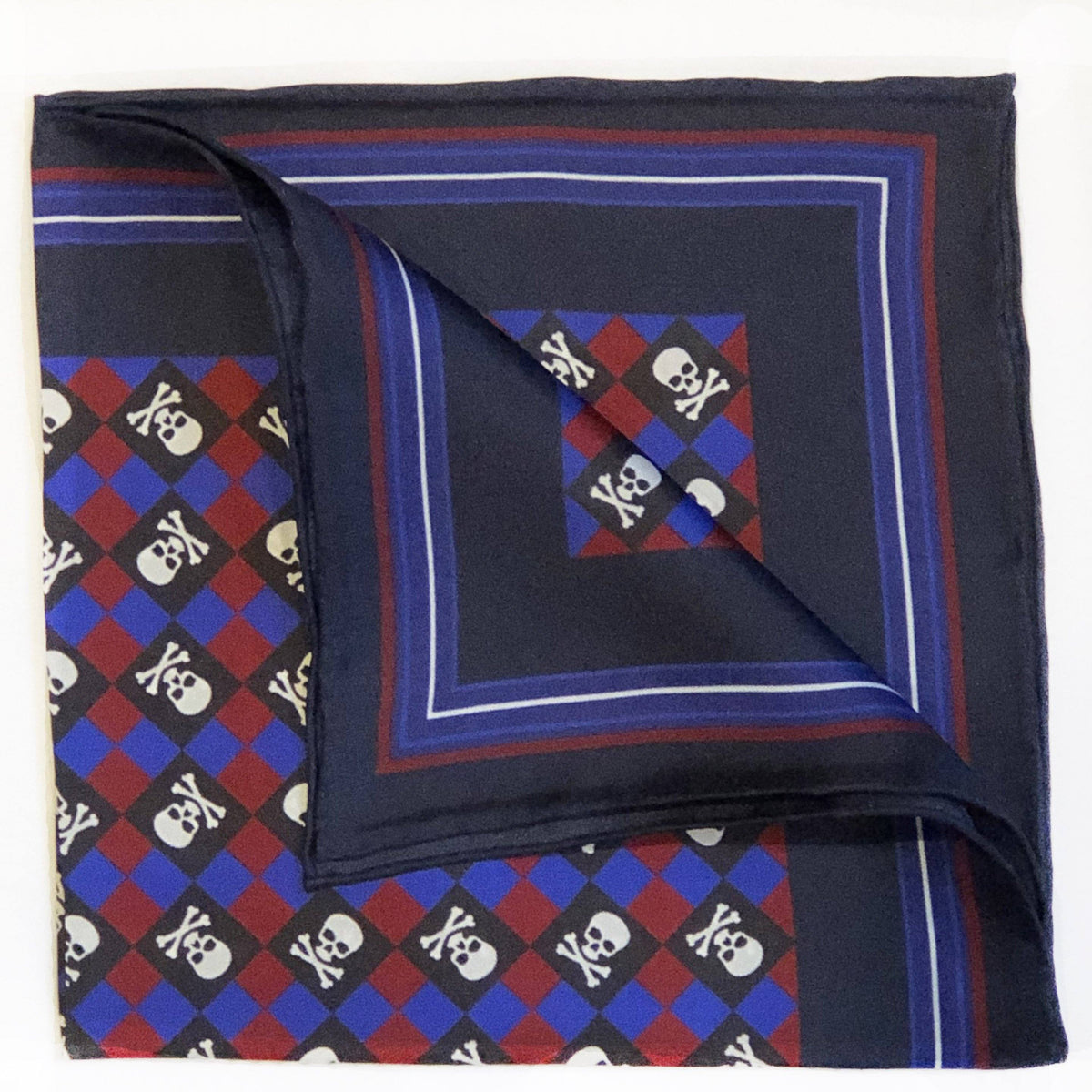 Silk pocket square with a navy centre and a red, blue and black harlequin border of white skulls and crossbones